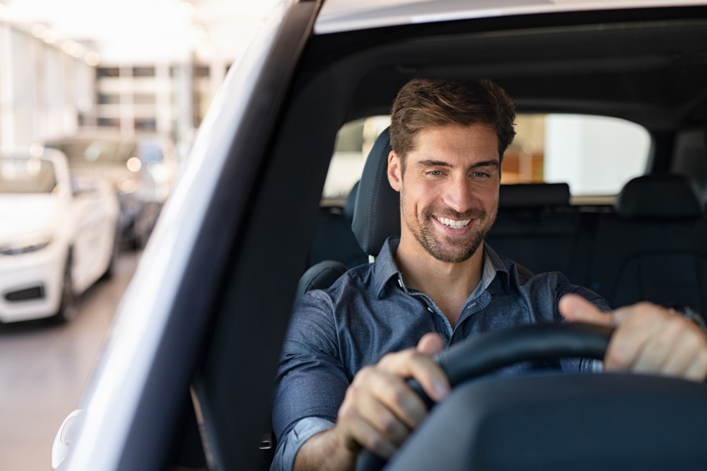 smiling man test driving a car he's about to buy